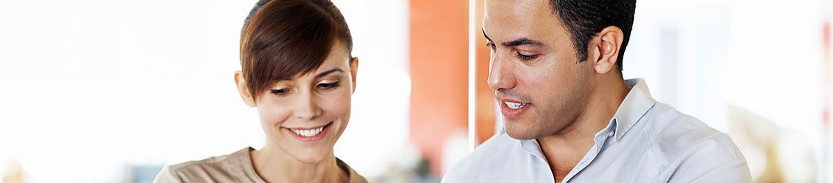 Smiling coworkers collaborating on financial records, highlighting Billing Services and administrative support solutions.