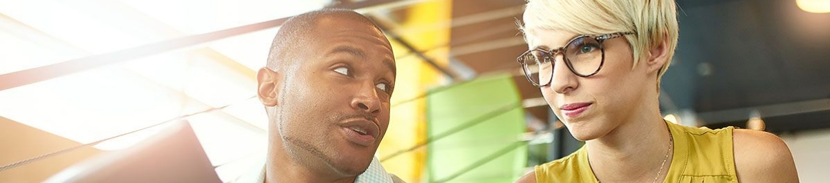 Professionals discussing compliance services for employee benefits administration in a bright office environment.