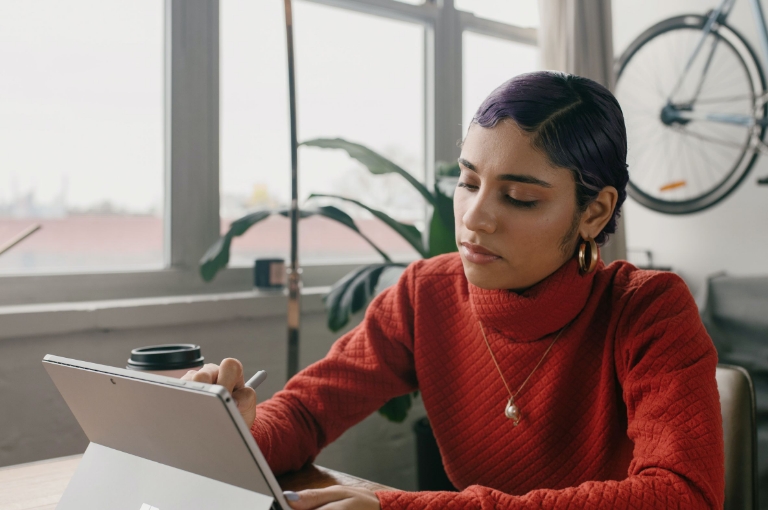 Professional woman working on a tablet in a modern office, representing employer support and guidance with HSA employer resources.