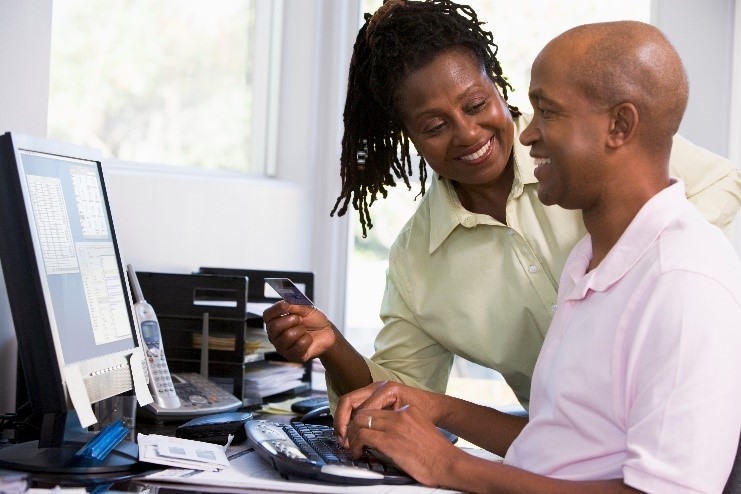 Smiling couple managing their Lifestyle Spending Account on a home computer, showing how flexible plan options can support health, wellness, and lifestyle goals.