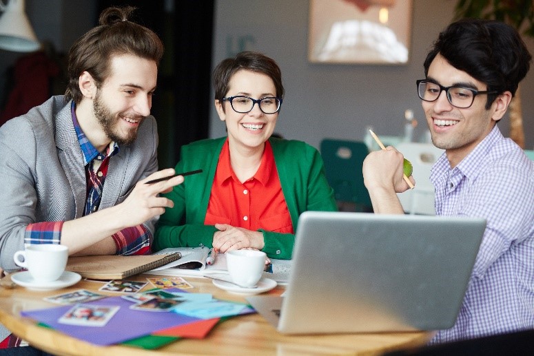 Young professionals collaborating over coffee in a bright, modern office setting, symbolizing how Lifestyle Spending Accounts empower employees to invest in wellness, learning, and work-life balance.