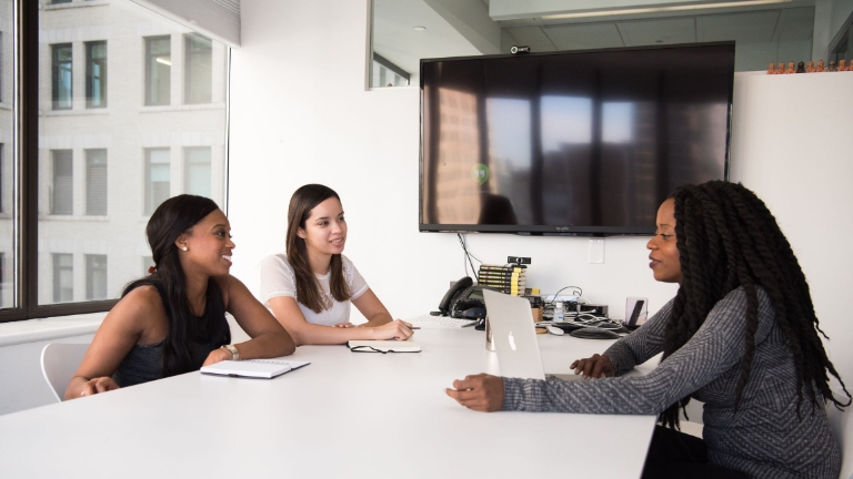 Team of employees in a conference room reviewing compliance services and nondiscrimination testing strategies.