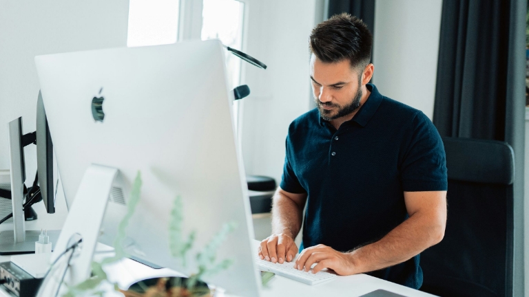 Man in office working on desktop computer, emphasizing reliable Billing Services Open Enrollment and benefits administration services.