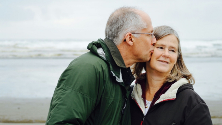 Senior couple enjoying a walk by the beach, symbolizing financial peace of mind with Retiree Billing Services for healthcare and benefits.